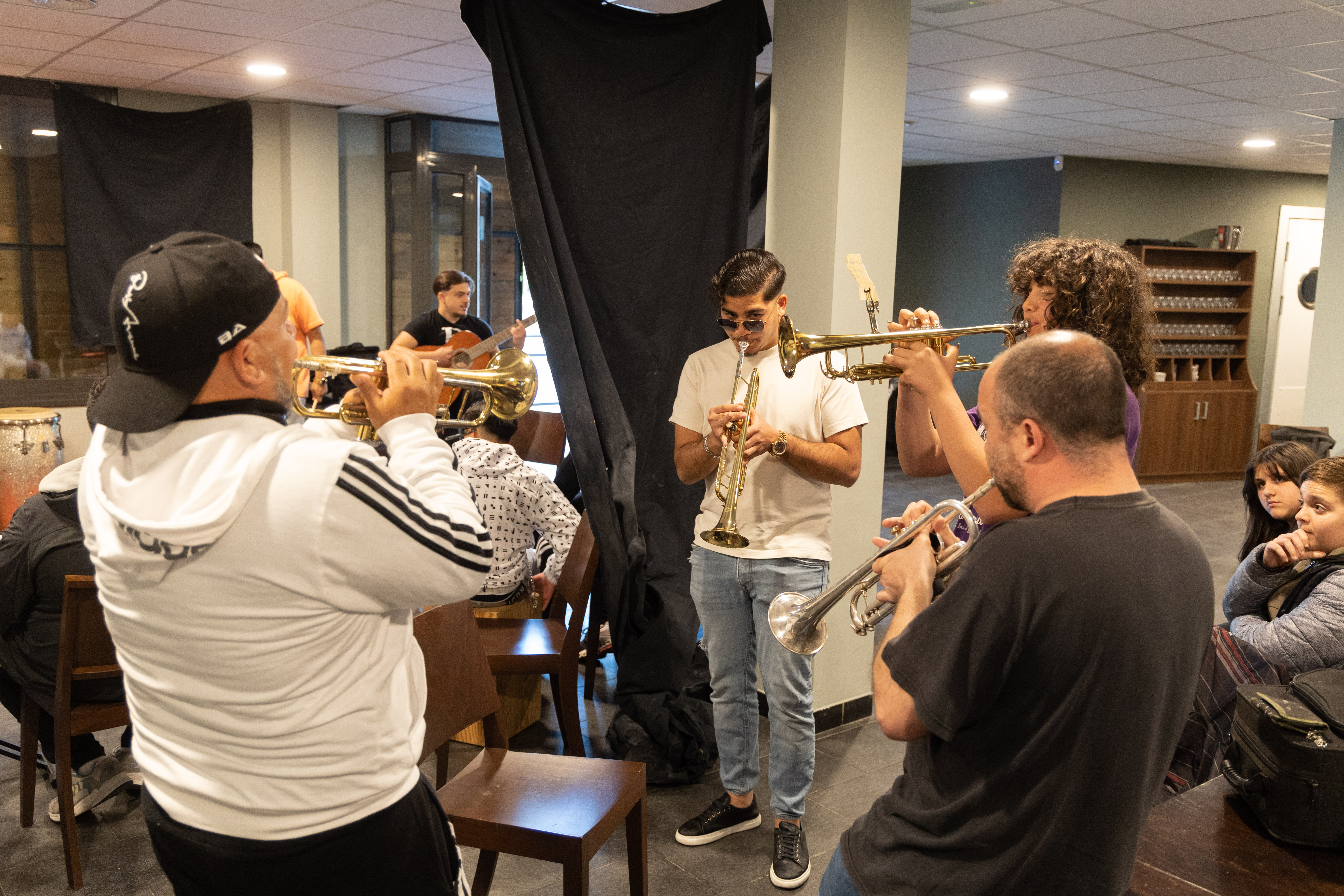 Veïns del barri toquen diferents instruments durant una sessió dels tallers