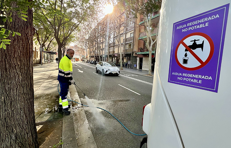 Un operari rega al carrer de Josep Torras i Bages amb aigua regenerada