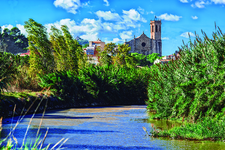 Vista de Sant Boi des del riu, amb l'església de Sant Baldiri al fons