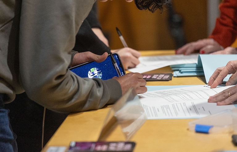 Una persona jove signa l'acceptació de la beca