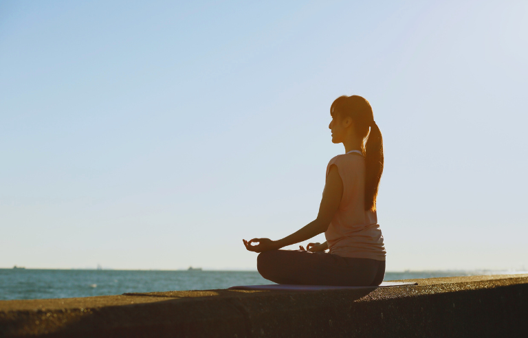Persona asseguda mirant el mar
