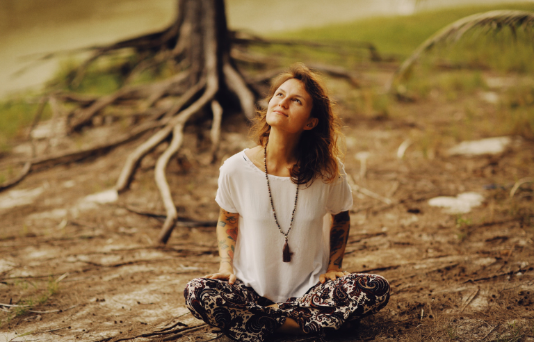 dona asseguda en un bosc