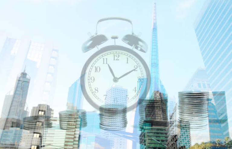 Un rellotge amb edificis al darrere de la imatge