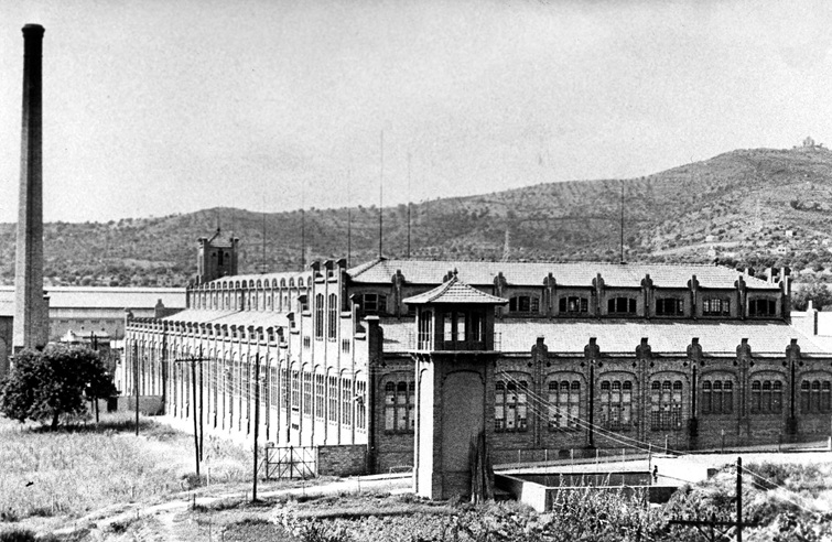 La fàbrica tèxtil de Can Massallera envoltada de garrofers