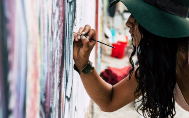 Noia pintant en paret
