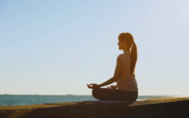 Persona asseguda mirant el mar