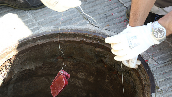 Aplicació d'un tractament antiplagues a un pou del clavegueram