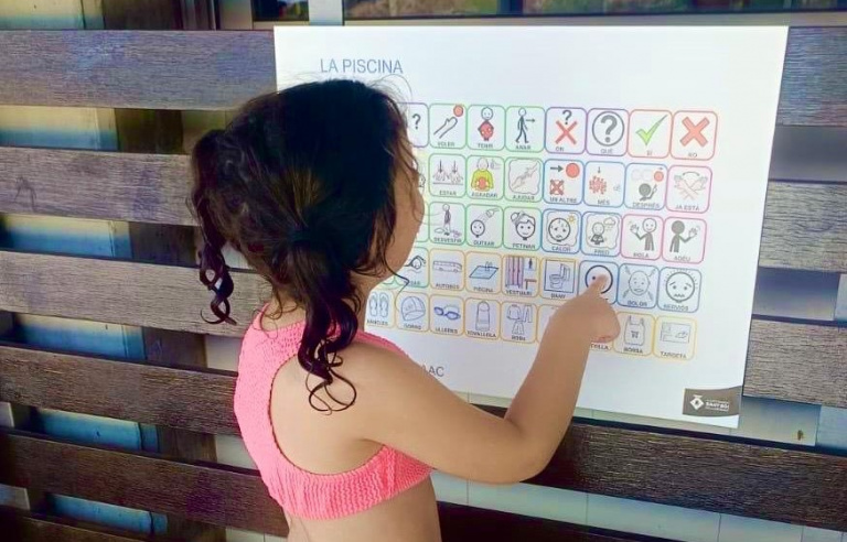 Una nena mira una seqüència de pictogrames en el primer dia de l'activitat