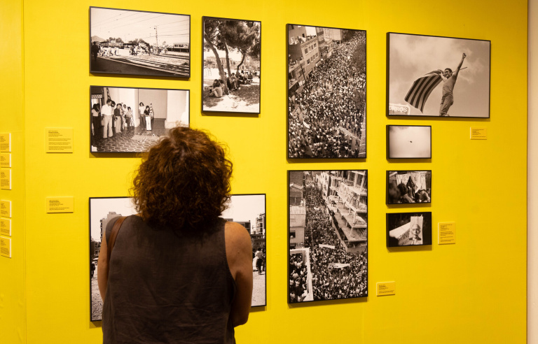 Una dona mira fotografies de l'exposició a una sala del Museu de Sant Boi